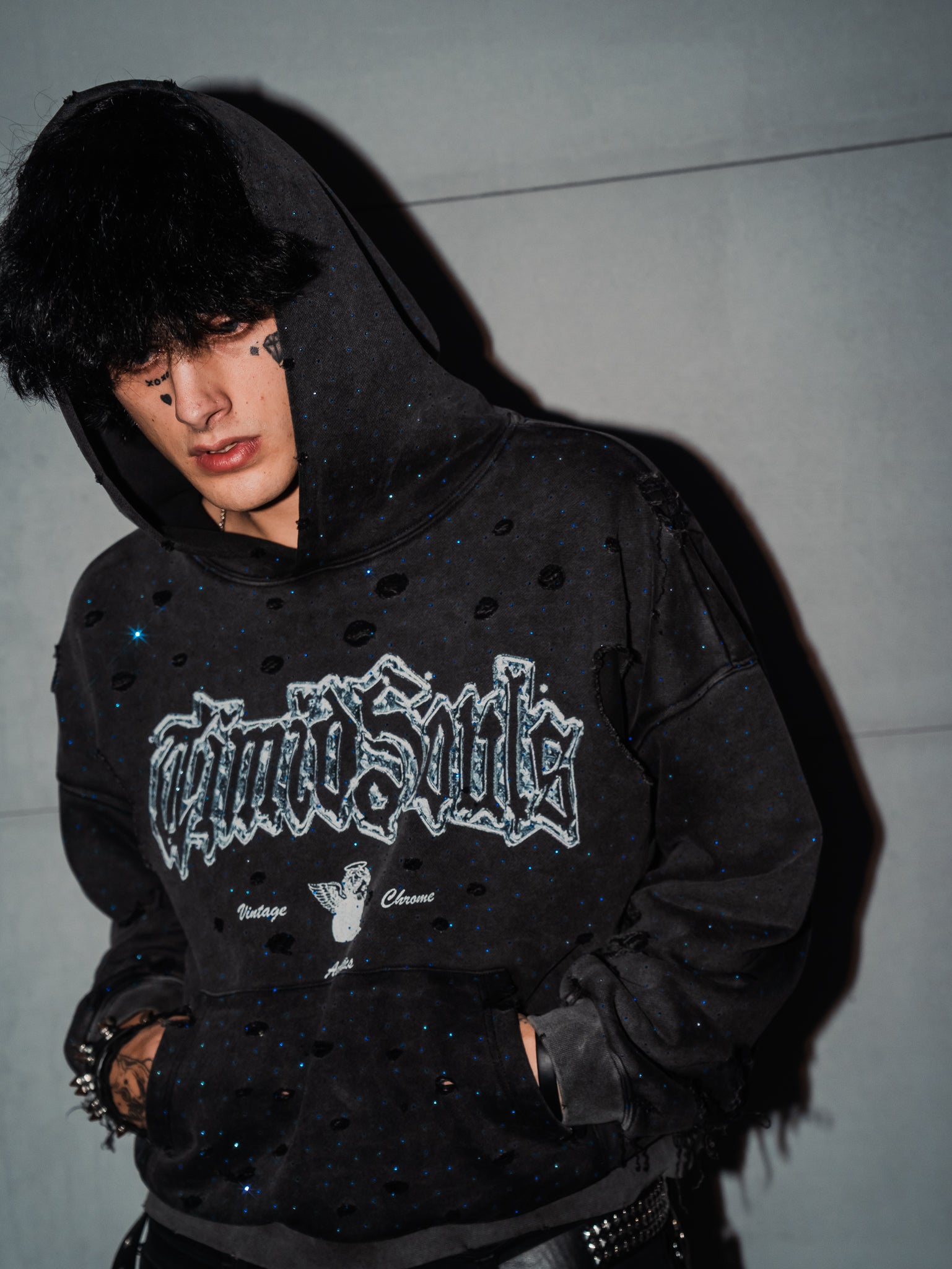 Person wearing a black hoodie with 'Cultured Souls' text against a plain background