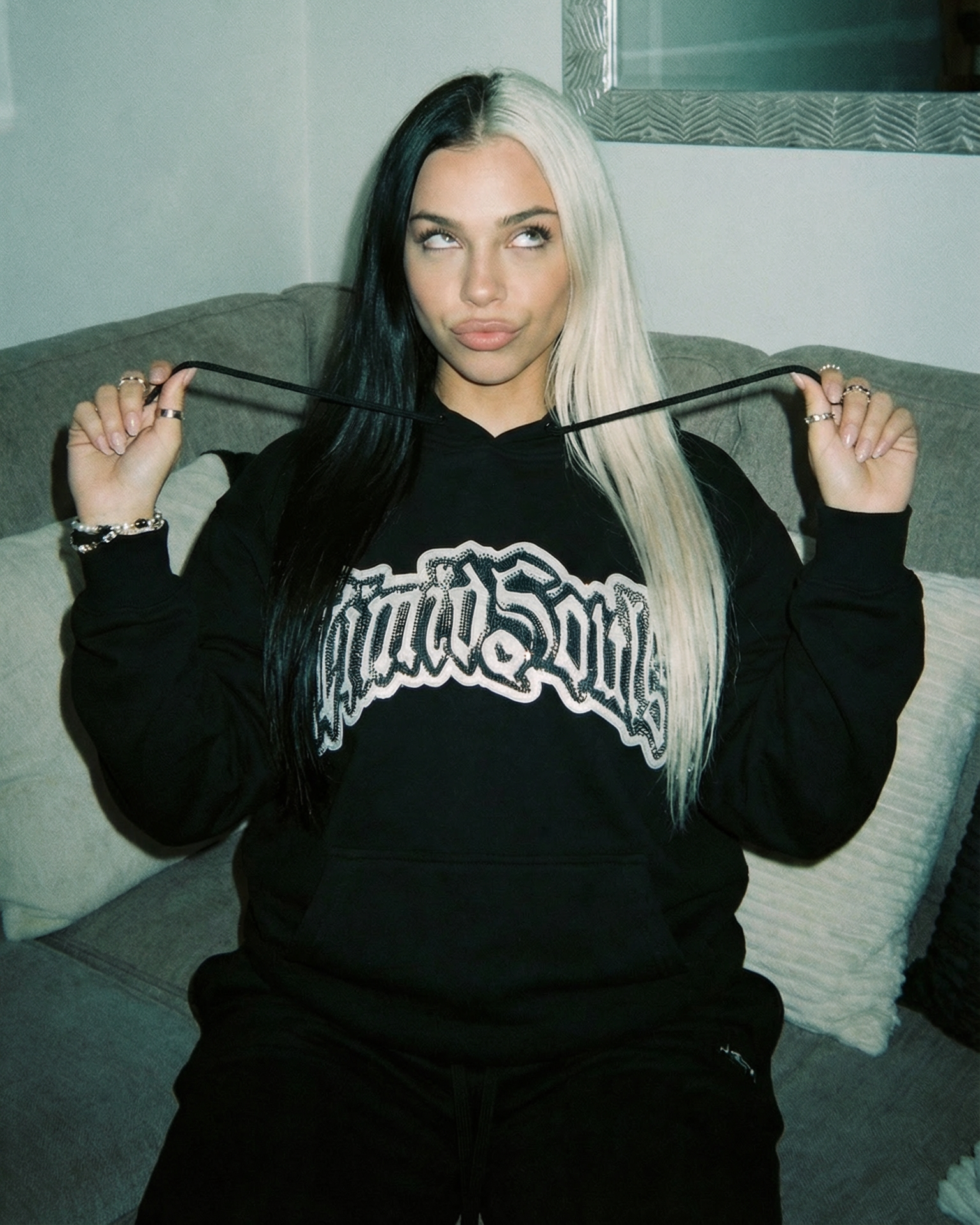 This image features a stylish "Black" LOGO® Hoodie, perfect for casual wear and made from all-cotton for comfort and durability. The hoodie sports a prominent blue rhinestone on the front, adding a touch of uniqueness and style.