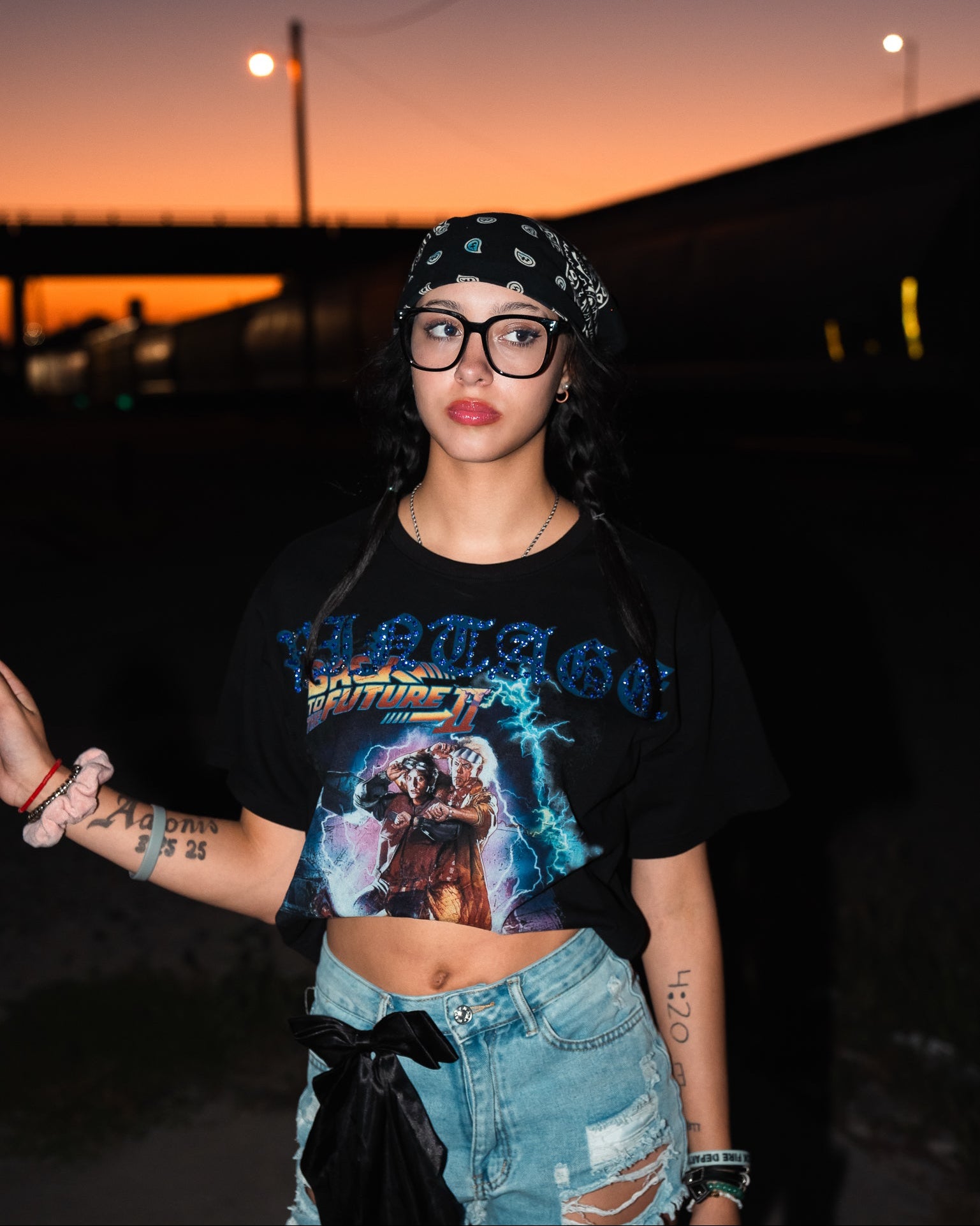 Person wearing a graphic t-shirt and bandana at sunset