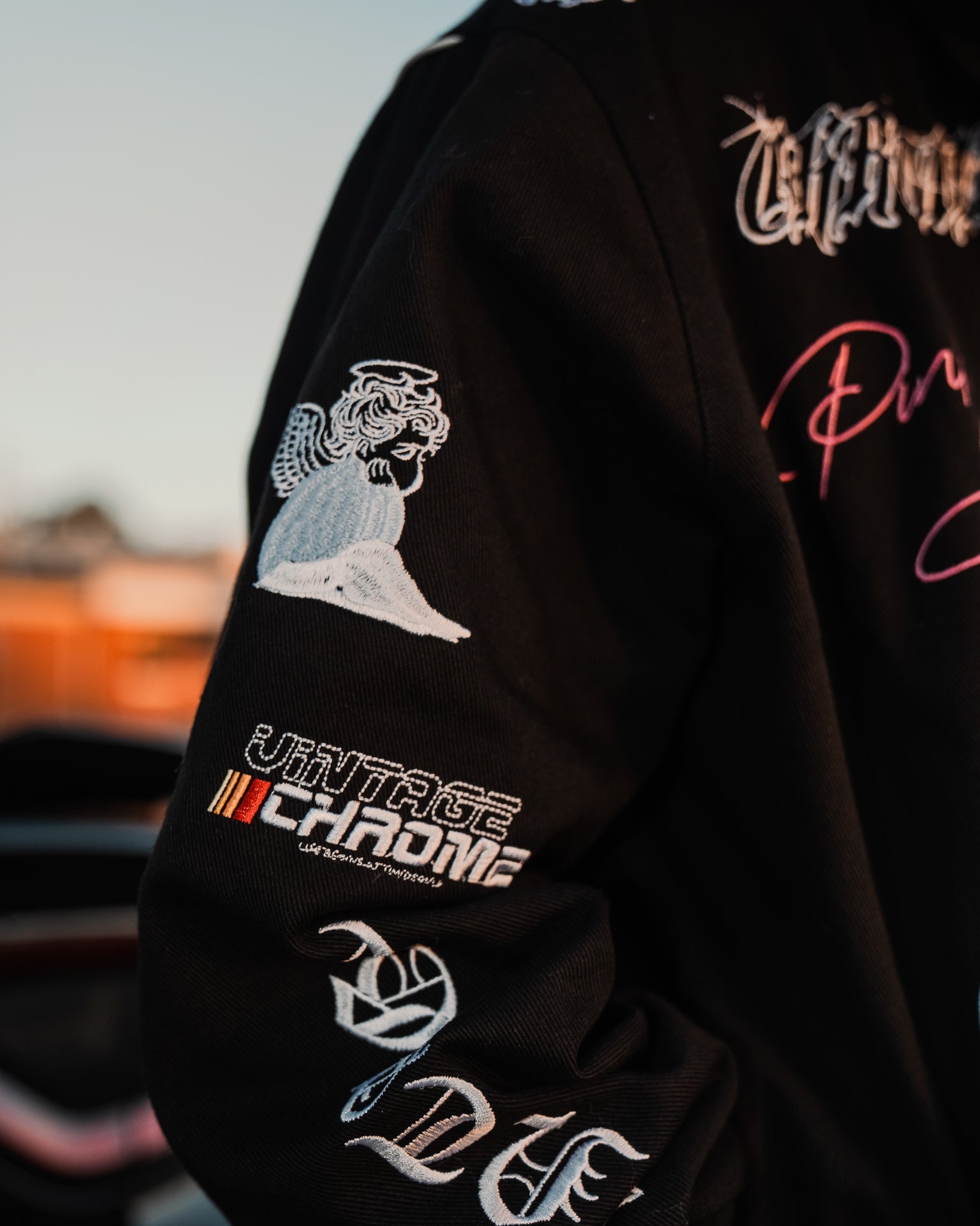 Black jacket with embroidered designs and text, blurred background